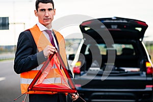 Man with car breakdown erecting warning triangle