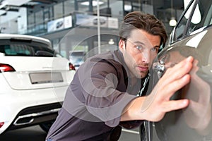 Man in the car dealership looks at a vehicle in the showroom