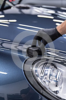 Man car detailing studio worker applying ceramic coating