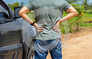 Man car driver has back pain after a long road trip drive.
