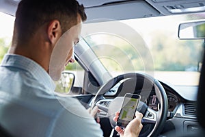 Man in the car and holding black mobile