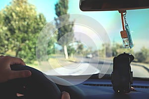 Man in the car and holding black mobile phone with map gps navigation, toned at sunset