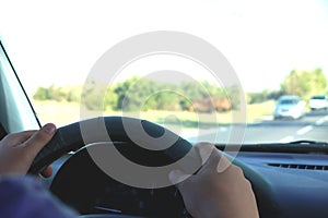 Man in the car and holding black mobile phone with map gps navigation, toned at sunset