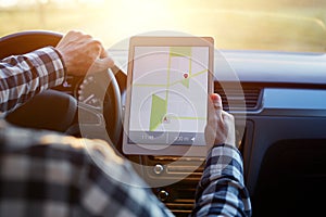 Man in car and holding tablet with map gps navigation