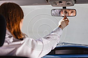 Man in car looking at mirror inside