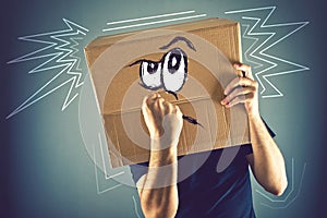 Man with cardboard box on his head and doodle drawing of angry f