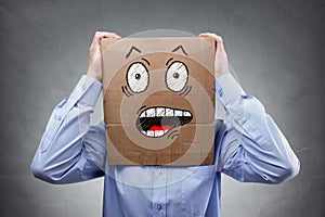 Man with cardboard box on his head showing shocked and surprised expression