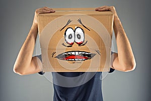 Man with cardboard box on his head and terrified look skethed photo