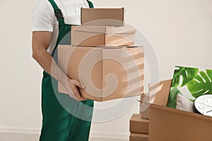 Man with cardboard boxes in room. Moving service