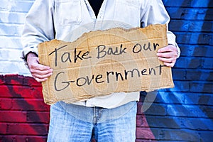 Man with cardboard sign, Take Back Our Government, with American Flag,