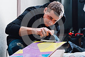 Man is careful waxing the snowboard