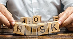 The man carelessly raises the word Risk. High risks in business, fragile balance and insecurity. Caution and anticipation photo