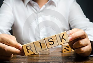 The man carelessly raises the word Risk. High risks in business, fragile balance and insecurity. Caution and anticipation photo