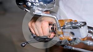 Man cares for motorcycle, adjusting brake lever in detailed shots