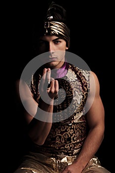 Man in carnival costume posing in studio while calling closer