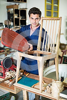 Man carpenter in furniture repair workshop