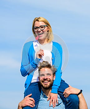 Man carries girlfriend on shoulders, sky background. Romantic date concept. Couple happy date having fun together