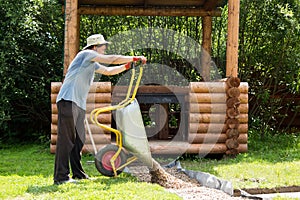 Man carries gravel for paths in wheelbarrow