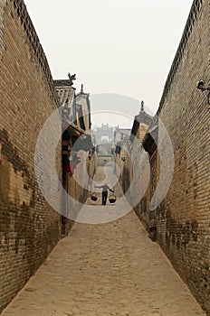 A man carries a pole in Ancient alley