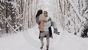 Man Carring Girl on Hands in Winter Forest. Love Story Concept. Copule Having Date in Nature