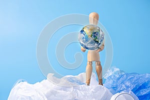 Man carry the planet to save the earth from garbage and plastic. Ecology and waste recycling. Elements furnished by NASA