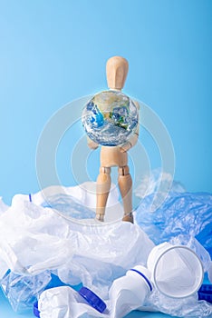 Man carry the planet to save the earth from garbage and plastic. Ecology and waste recycling. Elements furnished by NASA