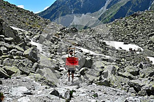 Muž nesoucí krabice dolů z horské chaty pod Rysmi u hory Rysy, vysoké tatry, slovensko