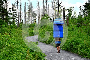 A man carrying boxes with supplies and groceries to a mountain lodge in the High Tatras, Slovakia