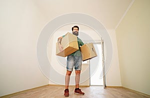 Man carrying cardboard box on moving day. Delivery man loading cardboard boxes for moving to an apartment.