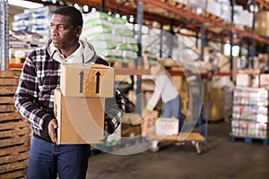 Man carrying cardboard boxes in warehouse