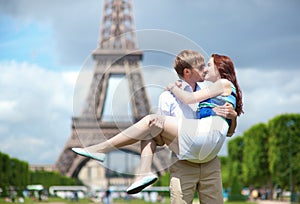 Man carrying girlfriend in his arms in Paris