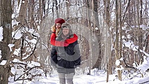 Man carrying his woman piggyback on a winter day