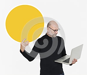 Man carrying a laptop and holding a round board