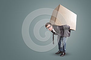 A man is carrying a large cardboard box - isolated on a neutral background with copy space