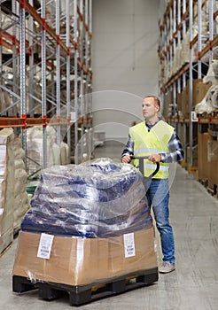 Man carrying loader with goods at warehouse