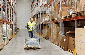 Man carrying loader with goods at warehouse