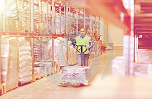 Man carrying loader with goods at warehouse