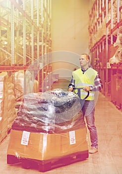 Man carrying loader with goods at warehouse
