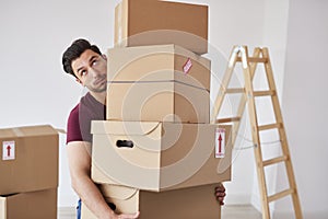 Man carrying stack of heavy cardboard boxes