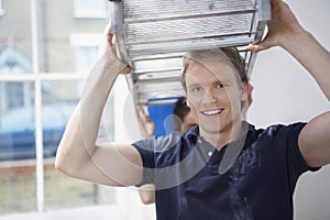 Man Carrying Stepladder With Woman Helping In Unrenovated House