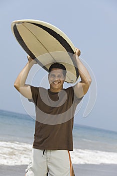 Man Carrying Surfboard Over His Head