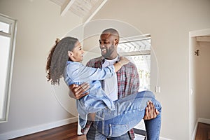 Man Carrying Woman Over Threshold Of Doorway In New Home