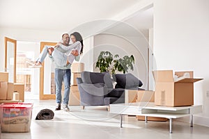 Man Carrying Woman Over Threshold Of New Home On Moving Day