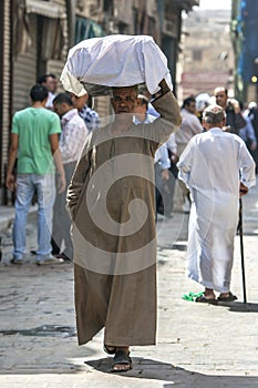 A man carrys a load of goods through the Khan el Khal'ili Bazaar in Cairo, Egypt.