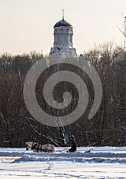 Man in the cart with white horse in winter park. Winter landscapes in Russia. photo
