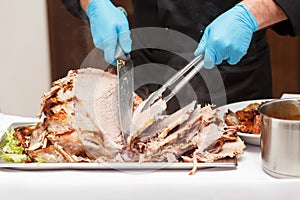 Man Carving Slices Of Roast ham