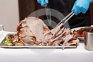 Man Carving Slices Of Roast ham