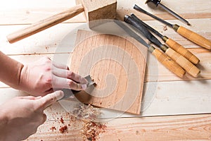 Man carving wood with handtools