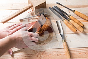 Man carving wood with handtools