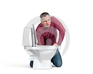 A man in casual clothes put his hand into the toilet and caught something there, isolated on a white background.